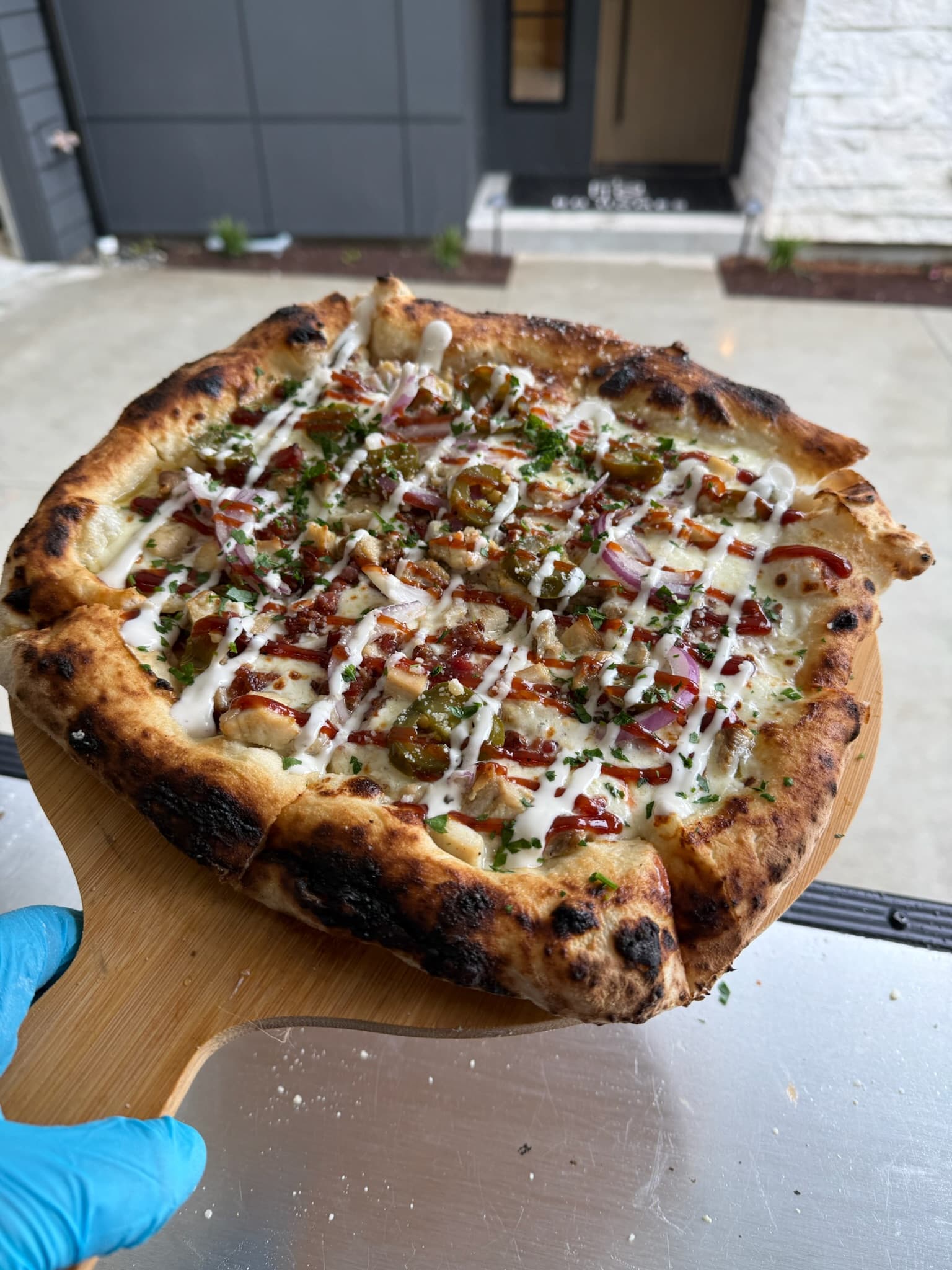 Close-up of a hand-stretched pizza being prepared for the wood-fired oven