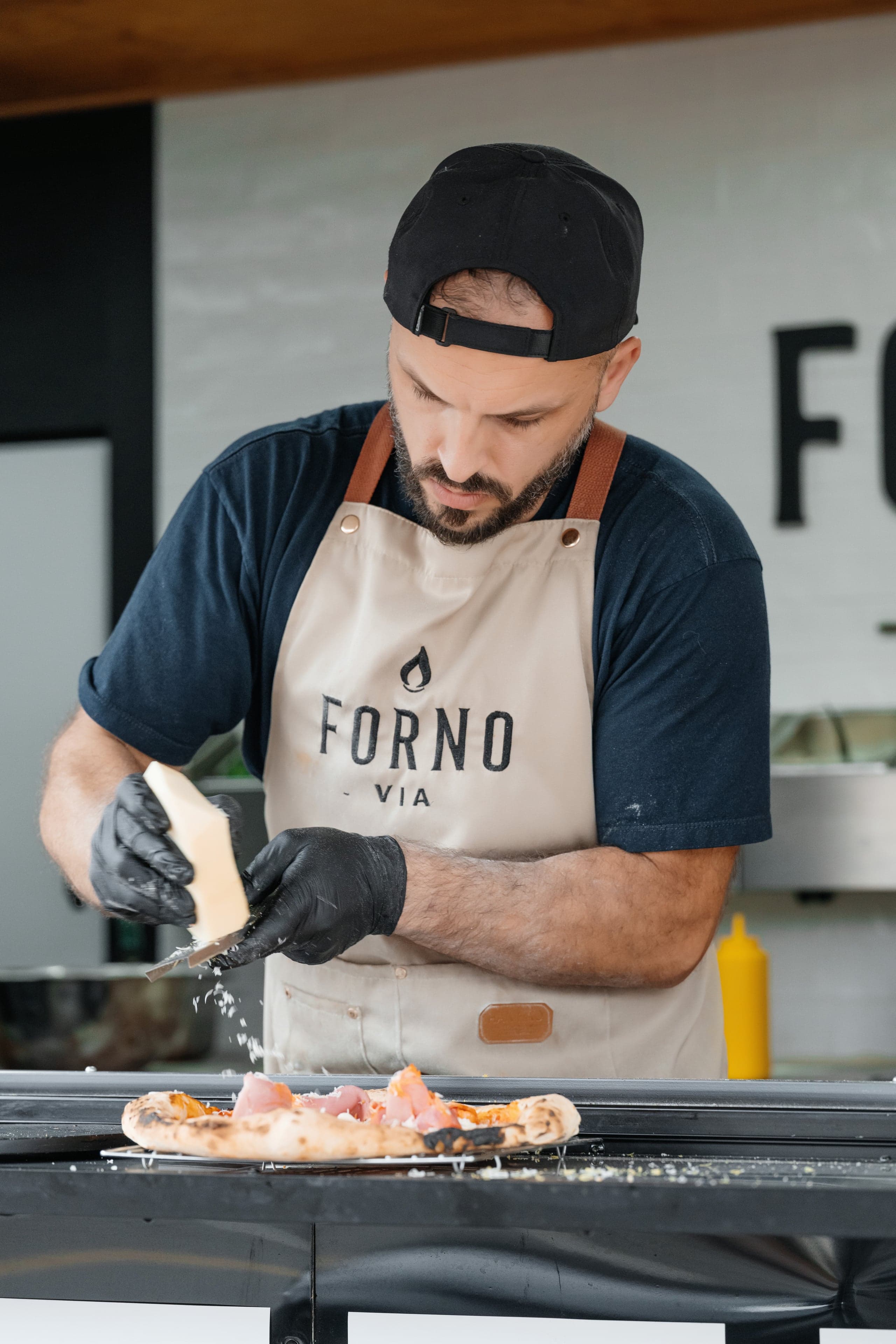 Chef Shpendi preparing authentic Neapolitan pizza in the wood-fired oven