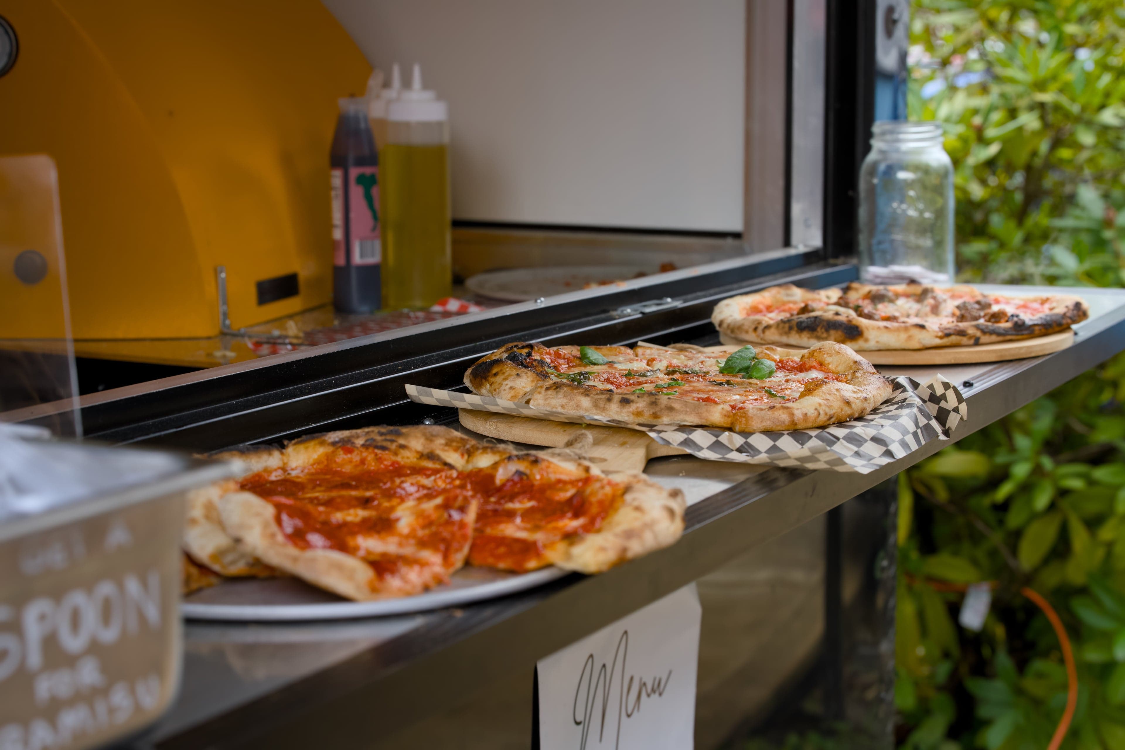 Wood-fired pizza being prepared at an outdoor Seattle wedding catered by Forno Via