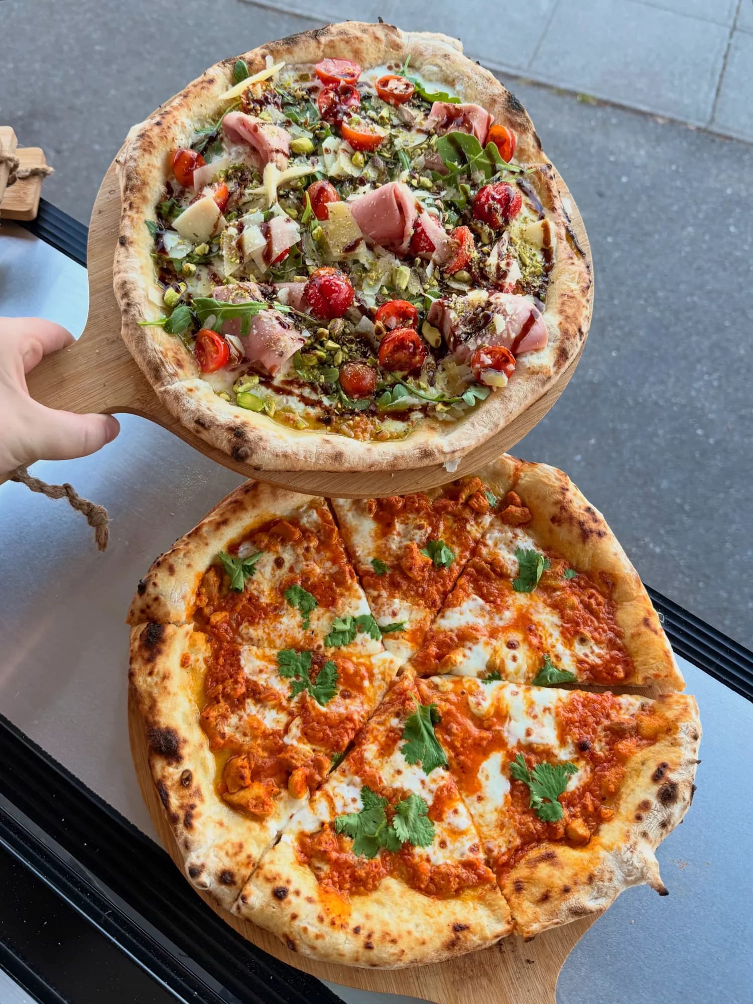 Two freshly baked Forno Via wood-fired pizzas with classic and seasonal toppings