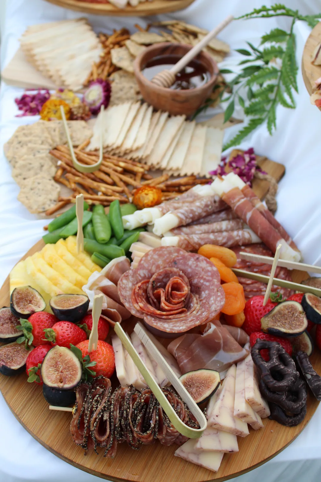 Close-up of a Forno Via grazing board with cured meats, cheeses, figs, fruit, crackers, and vegetables