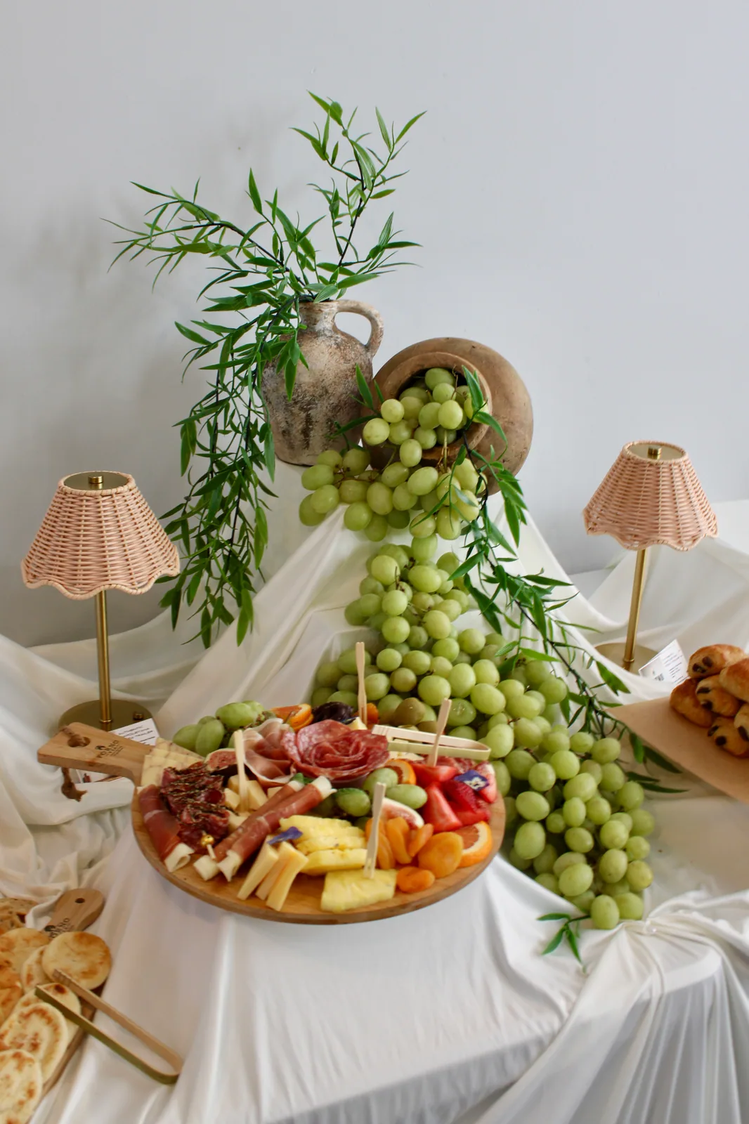 Styled Forno Via grazing table with cascading green grapes and charcuterie platters