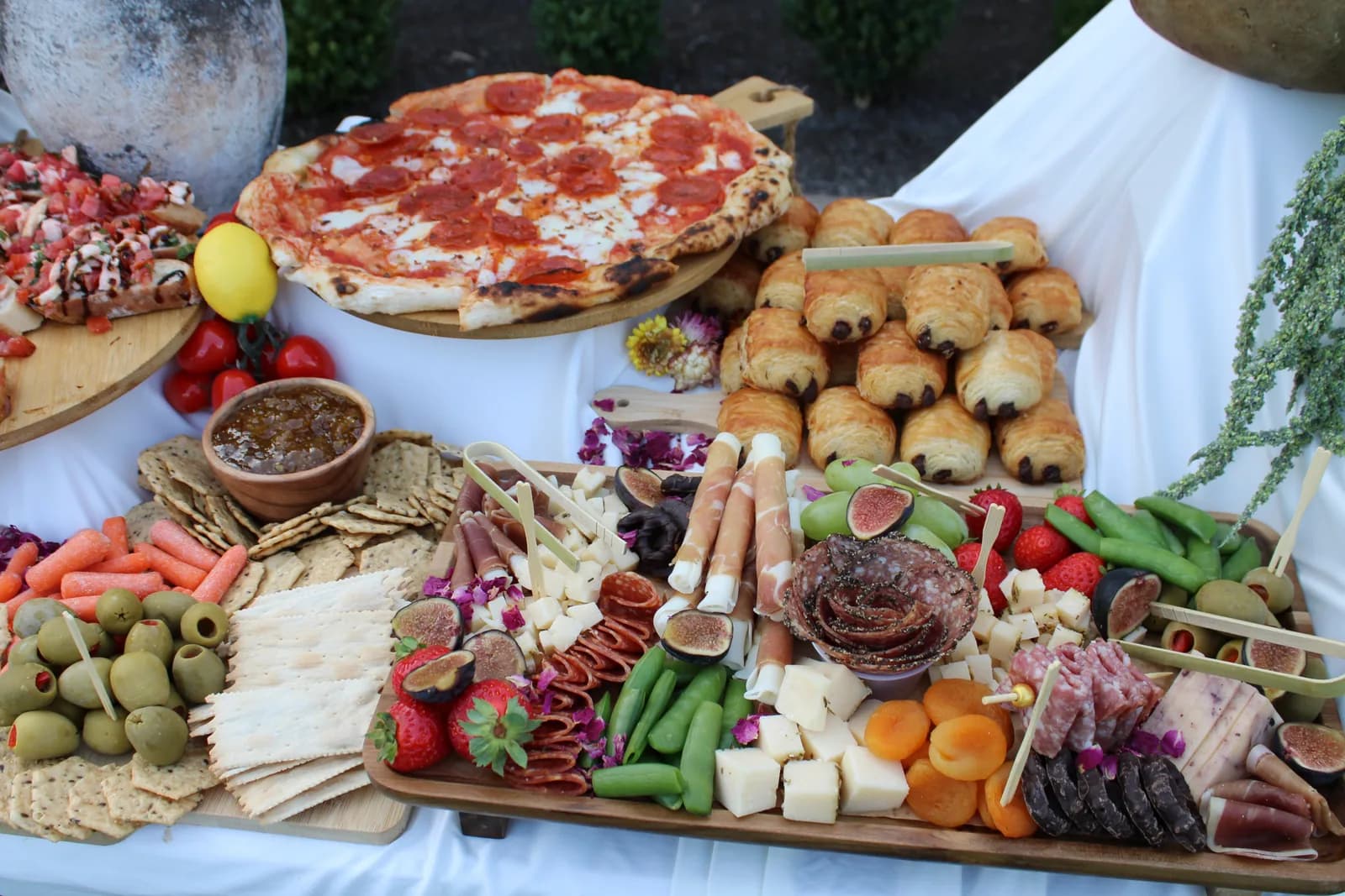 Forno Via grazing spread with pizza, charcuterie, cheeses, fruit, olives, and breads